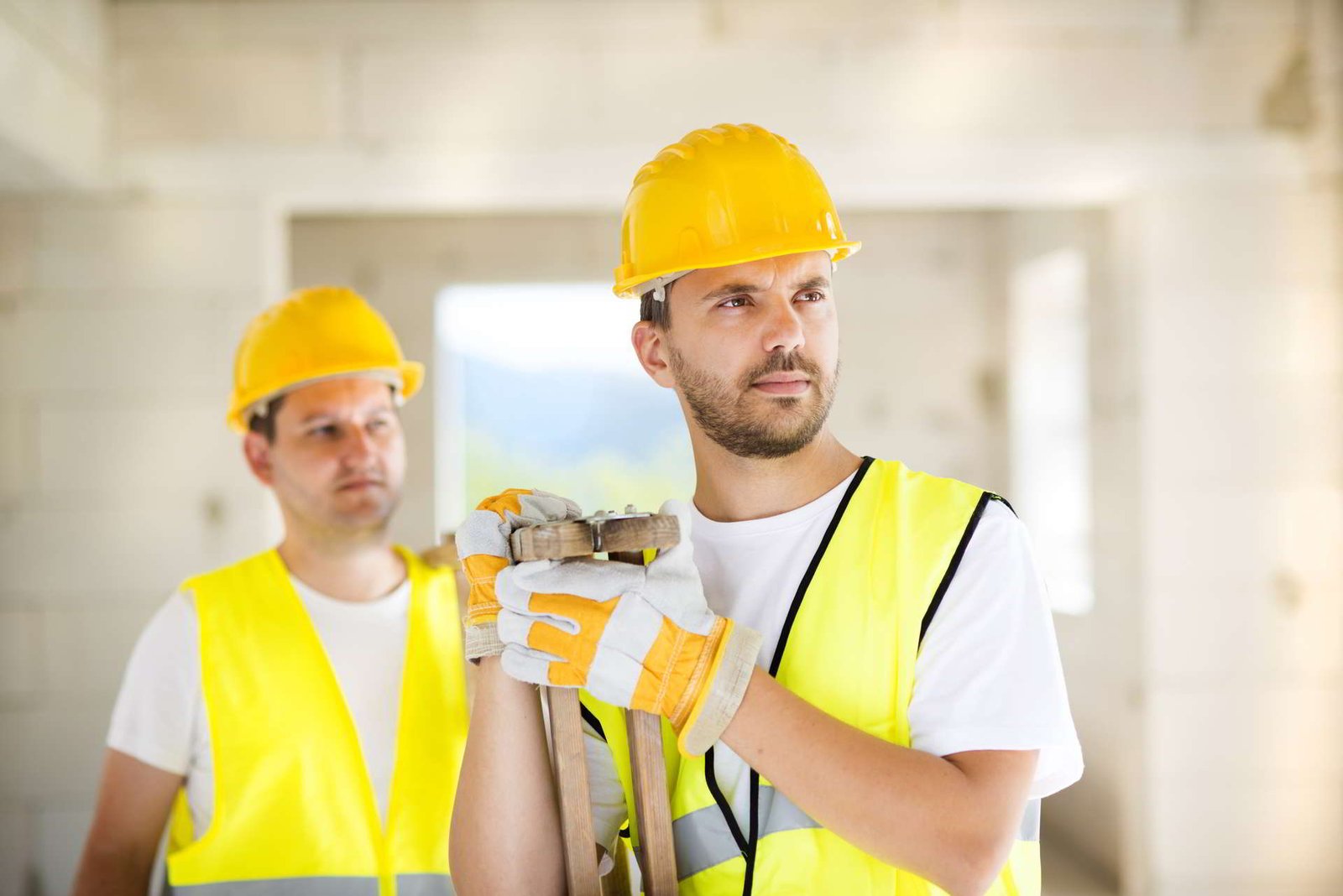 construction-workers-collaborating-on-new-house-building-SBI-304922727